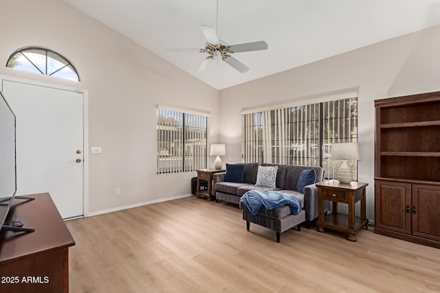 living area featuring high vaulted ceiling, light wood finished floors, baseboards, and a ceiling fan