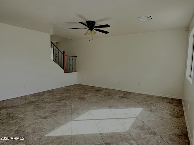 spare room featuring baseboards, stairs, visible vents, and a ceiling fan