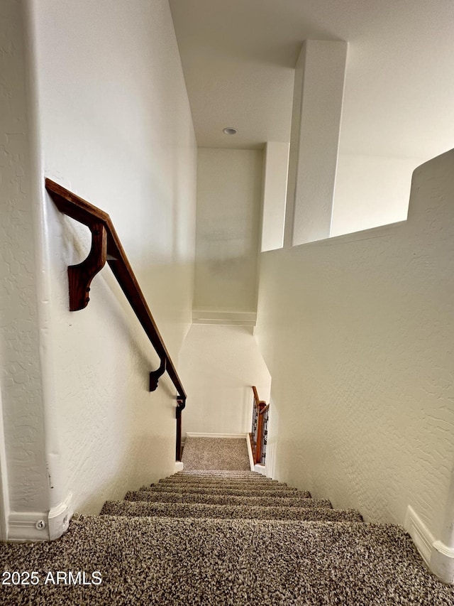 stairs featuring carpet floors and a textured wall