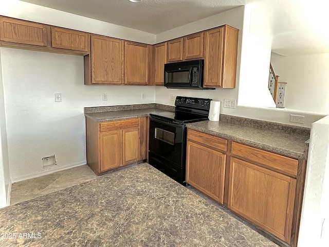 kitchen with dark countertops, baseboards, brown cabinets, and black appliances