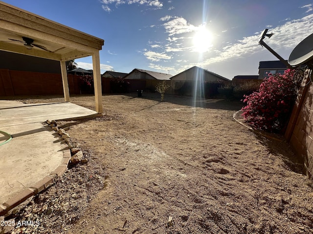 view of yard with a patio area, ceiling fan, and fence