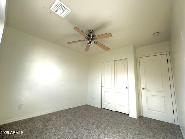 unfurnished bedroom featuring baseboards, visible vents, ceiling fan, carpet, and a closet