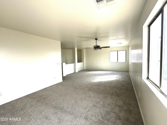 spare room with a ceiling fan, carpet, and visible vents