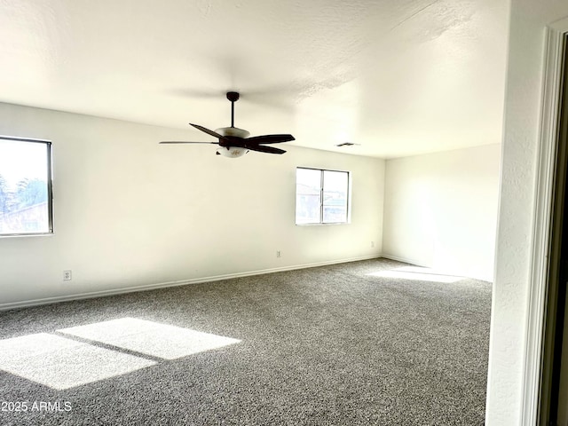 spare room with a ceiling fan, carpet, visible vents, and baseboards