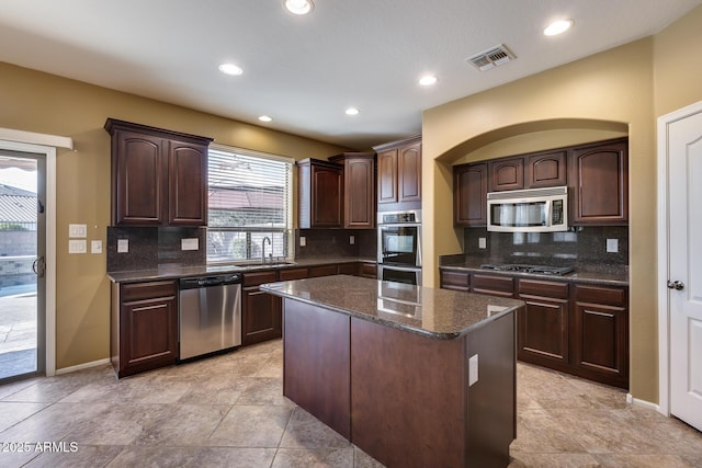 kitchen with tasteful backsplash, dark brown cabinets, sink, and stainless steel appliances