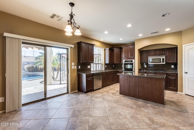 kitchen with decorative light fixtures, a center island, dark brown cabinetry, stainless steel appliances, and a chandelier