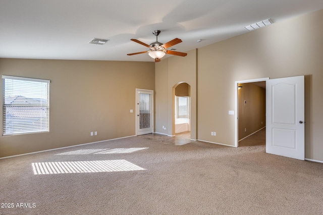 carpeted spare room with ceiling fan and high vaulted ceiling