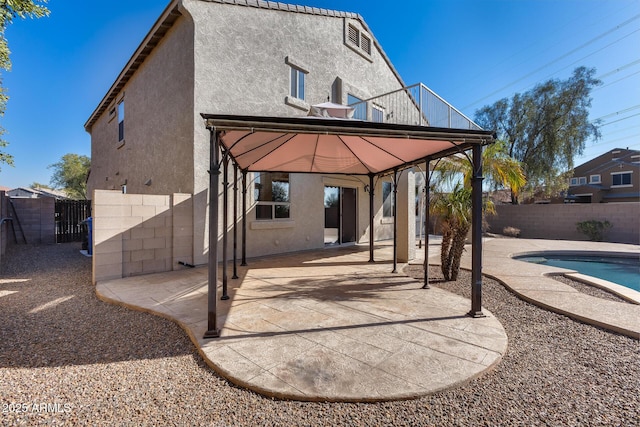 back of house with a patio area, a gazebo, a balcony, and a fenced in pool