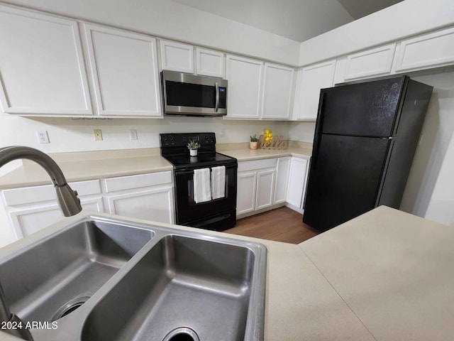 kitchen featuring black appliances, dark hardwood / wood-style floors, white cabinetry, and sink