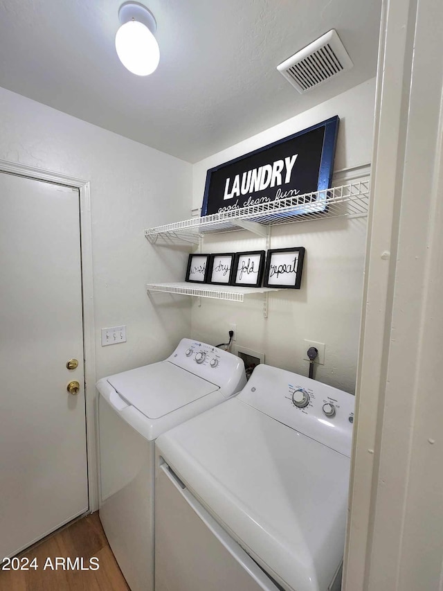 laundry area with hardwood / wood-style floors and separate washer and dryer