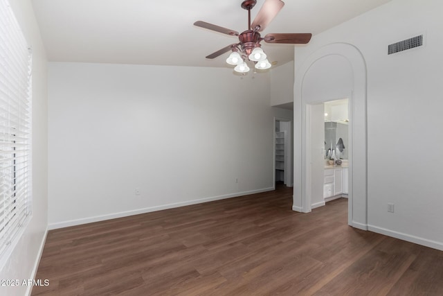 unfurnished bedroom featuring ceiling fan, dark hardwood / wood-style floors, and multiple windows