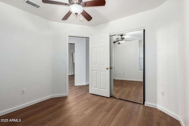 unfurnished bedroom with hardwood / wood-style flooring, ceiling fan, and a closet