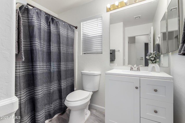 bathroom featuring vanity, wood-type flooring, and toilet