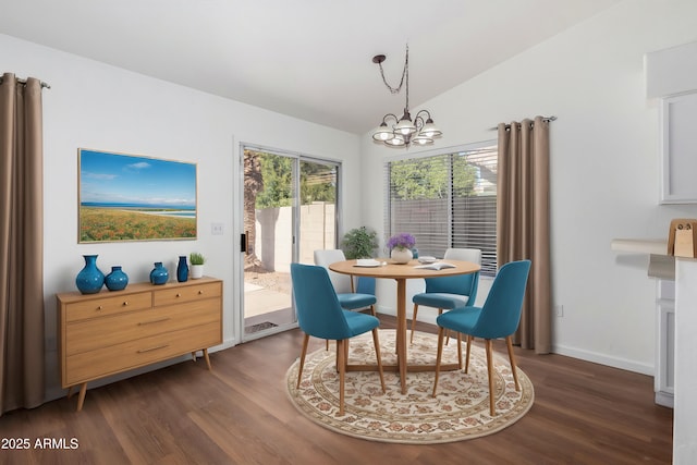 dining room featuring dark hardwood / wood-style floors, vaulted ceiling, and an inviting chandelier