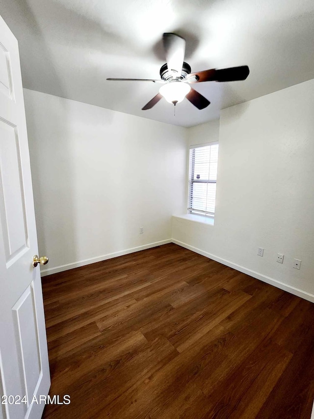 unfurnished room with dark hardwood / wood-style floors and ceiling fan