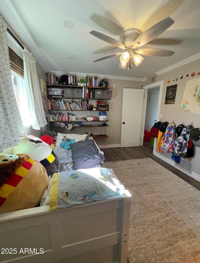 bedroom featuring ceiling fan, wood-type flooring, and ornamental molding