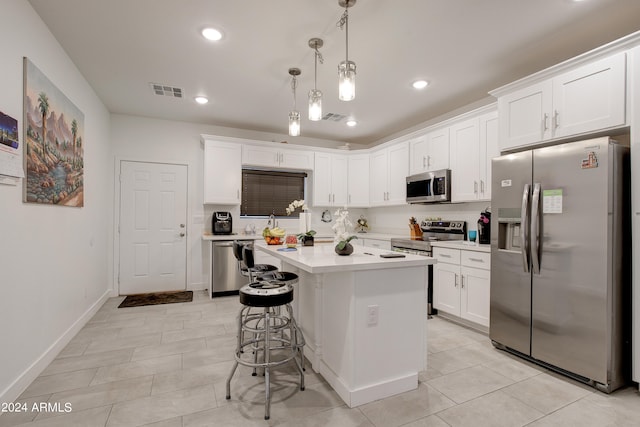 kitchen with a center island, stainless steel appliances, white cabinetry, a kitchen bar, and decorative light fixtures