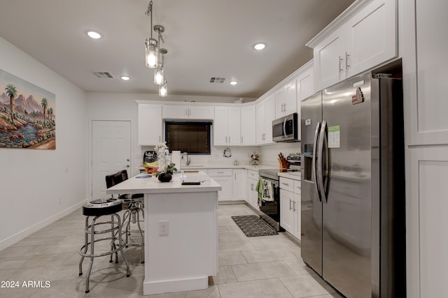 kitchen featuring a center island, white cabinets, pendant lighting, appliances with stainless steel finishes, and a kitchen breakfast bar