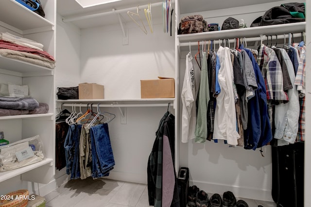 walk in closet with light tile patterned floors