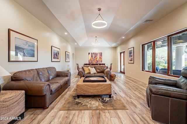 living room featuring light hardwood / wood-style floors and a tray ceiling