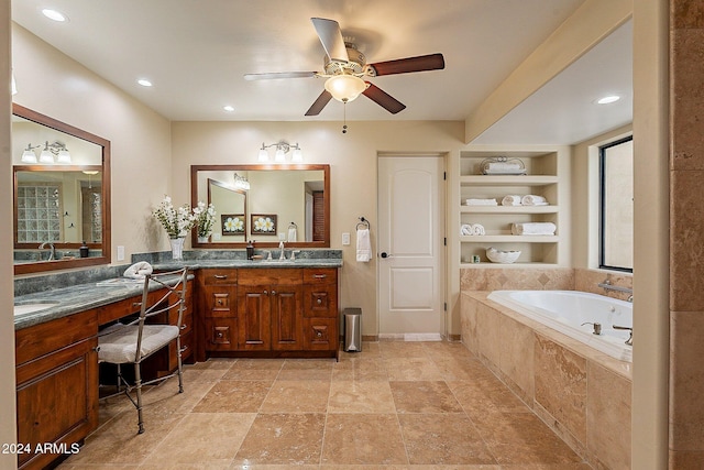 bathroom featuring vanity, a relaxing tiled tub, and ceiling fan