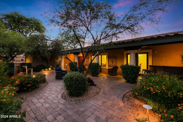 back house at dusk with a patio