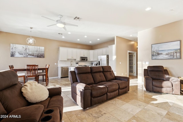 living room featuring light tile patterned flooring, ceiling fan, and sink