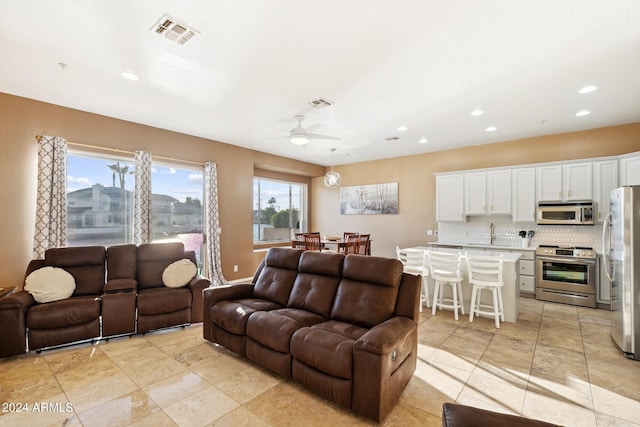 tiled living room featuring ceiling fan