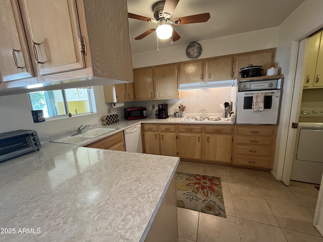 kitchen featuring sink, white appliances, light tile patterned flooring, washer / clothes dryer, and light brown cabinets