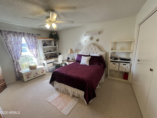 carpeted bedroom featuring ceiling fan and a textured ceiling