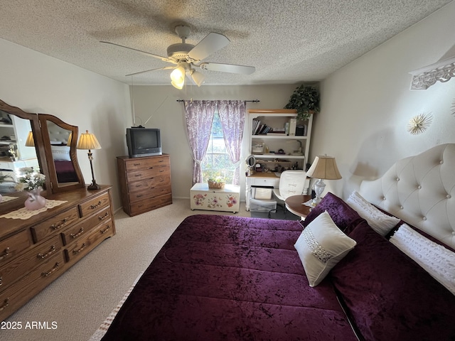 bedroom with ceiling fan, light carpet, and a textured ceiling