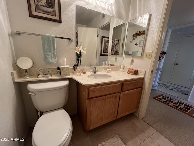 bathroom with tile patterned flooring, vanity, and toilet