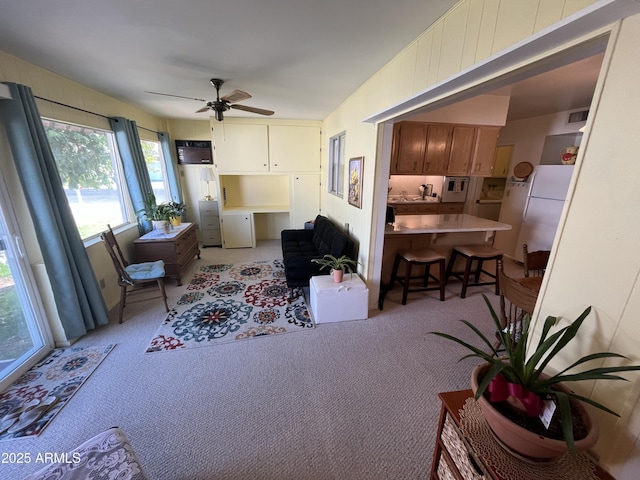 carpeted living room featuring ceiling fan