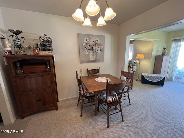 carpeted dining area featuring a notable chandelier