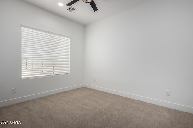 spare room featuring light carpet and ceiling fan