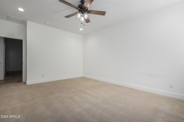 spare room with ceiling fan and light colored carpet