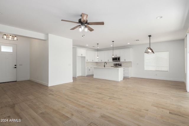 unfurnished living room featuring ceiling fan and light hardwood / wood-style floors