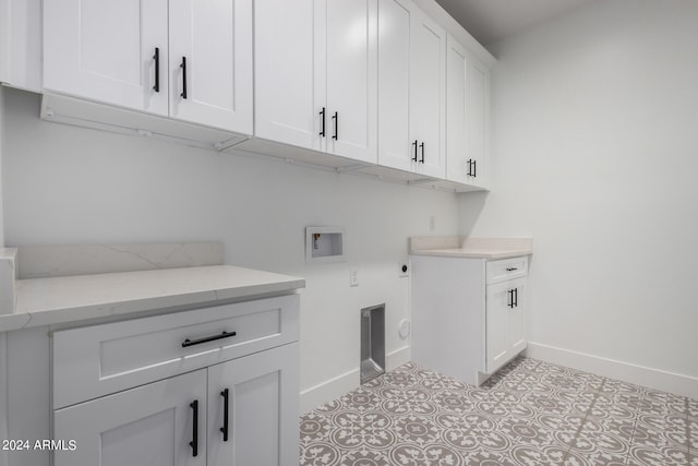 clothes washing area with washer hookup, cabinets, and electric dryer hookup