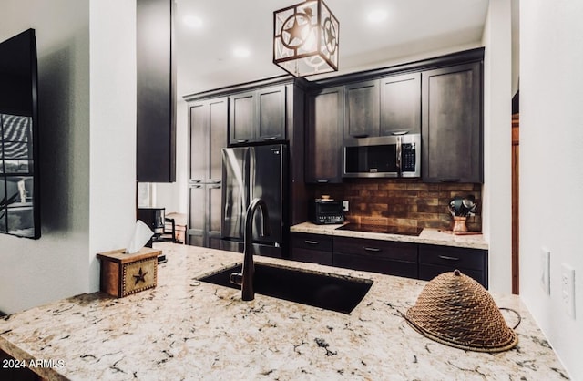 14950 W Mountain View Blvd Unit 4205, Surprise, AZ 85374 - kitchen featuring black appliances, a sink, decorative backsplash, light stone counters, and pendant lighting