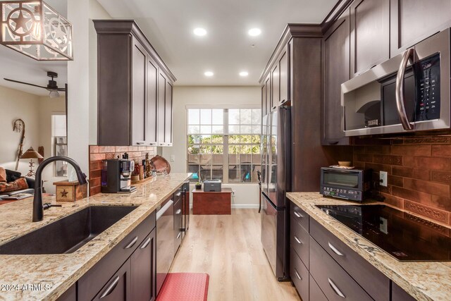 14950 W Mountain View Blvd Unit 4205, Surprise, AZ 85374 - kitchen featuring stainless steel appliances, a sink, light wood-type flooring, tasteful backsplash, and light stone counters
