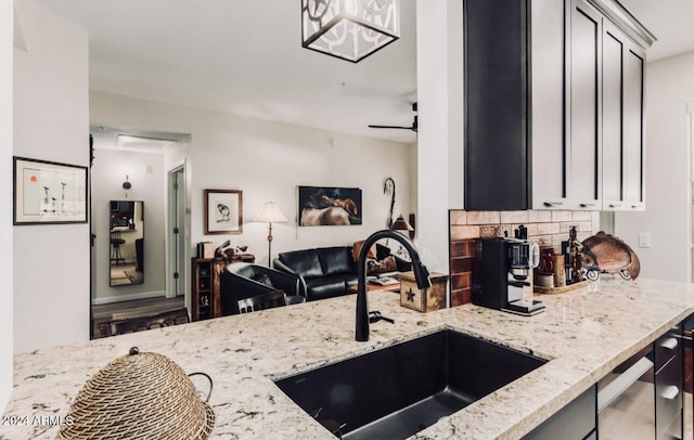 14950 W Mountain View Blvd Unit 4205, Surprise, AZ 85374 - kitchen with a sink, light stone countertops, open floor plan, decorative backsplash, and a ceiling fan