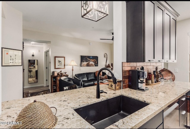 14950 W Mountain View Blvd Unit 4205, Surprise, AZ 85374 - kitchen featuring a sink, light stone countertops, open floor plan, and backsplash