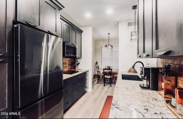 14950 W Mountain View Blvd Unit 4205, Surprise, AZ 85374 - kitchen featuring freestanding refrigerator, stainless steel microwave, a sink, tasteful backsplash, and light wood-type flooring