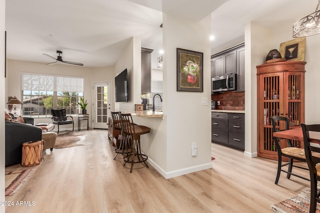 kitchen with ceiling fan, light hardwood / wood-style floors, sink, and tasteful backsplash