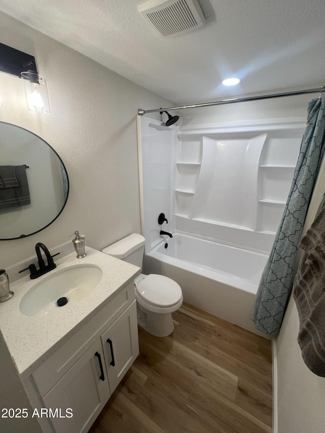 1545 W Marco Polo Rd, Phoenix, AZ 85027 - full bathroom with wood finished floors, a textured ceiling, shower / bathtub combination with curtain, vanity, and toilet