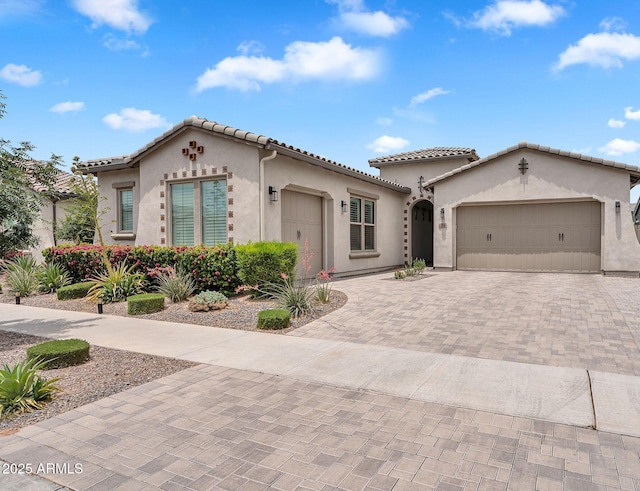 10006 E Rotation Dr, Mesa, AZ 85212 - mediterranean / spanish-style home with stucco siding, a garage, decorative driveway, and a tiled roof