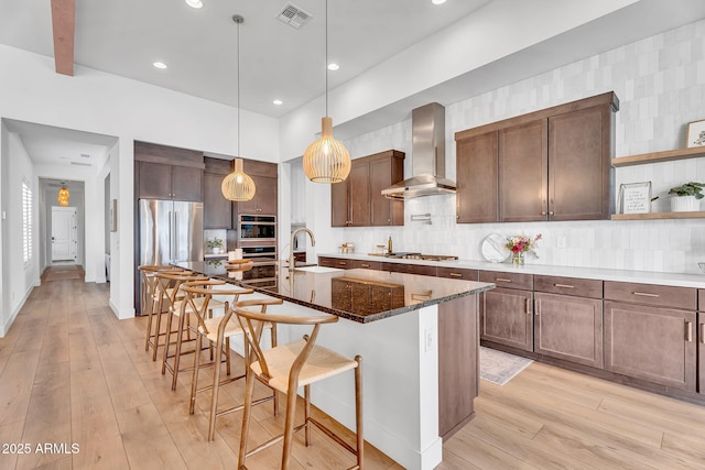10006 E Rotation Dr, Mesa, AZ 85212 - kitchen with wall chimney exhaust hood, stainless steel appliances, open shelves, light wood-style flooring, and recessed lighting