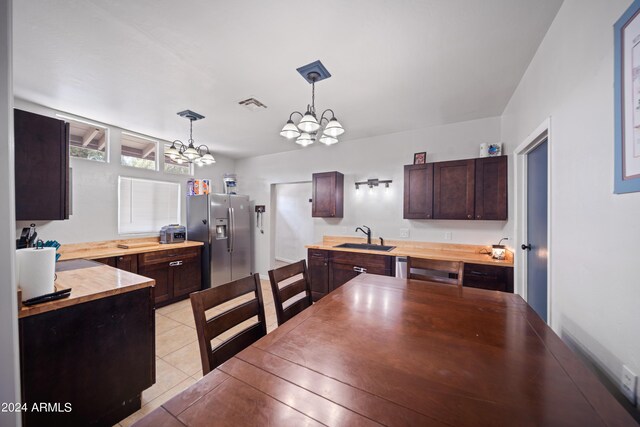 dining space featuring sink, light tile patterned flooring, and a chandelier