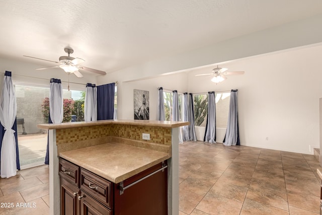kitchen with light countertops, ceiling fan, and dark brown cabinetry