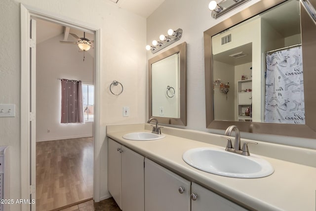 bathroom featuring double vanity, ceiling fan, a sink, and wood finished floors